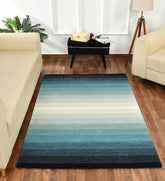 Modern artisan rug featuring teal, cream, and navy gradient